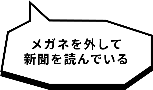 メガネを外して新聞を読んでいる
